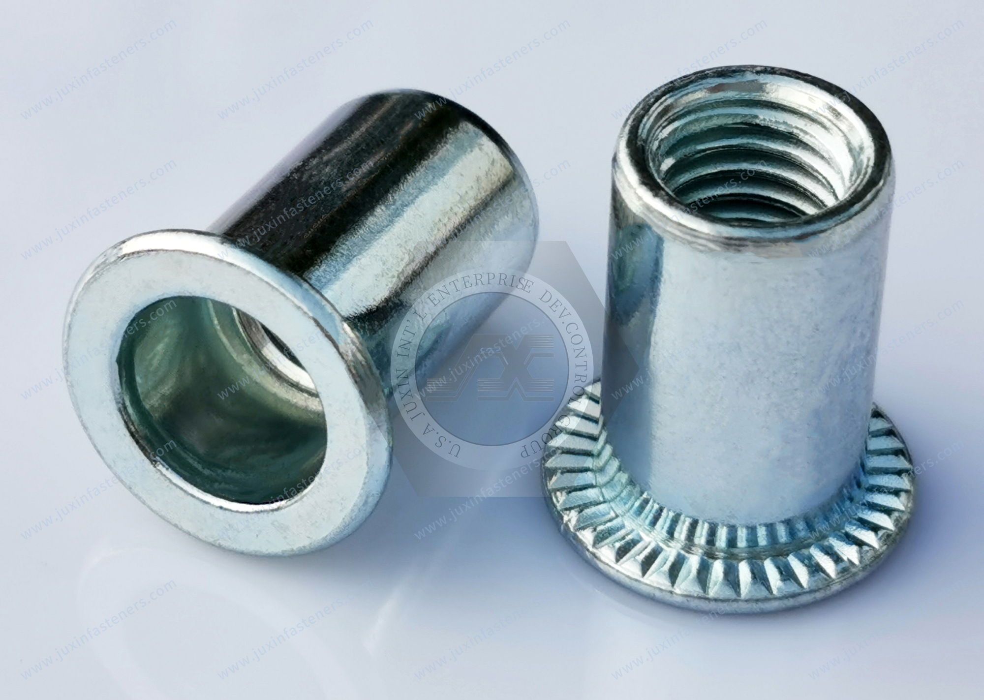 Fotografía original JUXIN JX-F: tuercas remachables de acero, cabeza plana, extremo abierto y cuerpo redondo liso, con zincado azul-blanco.